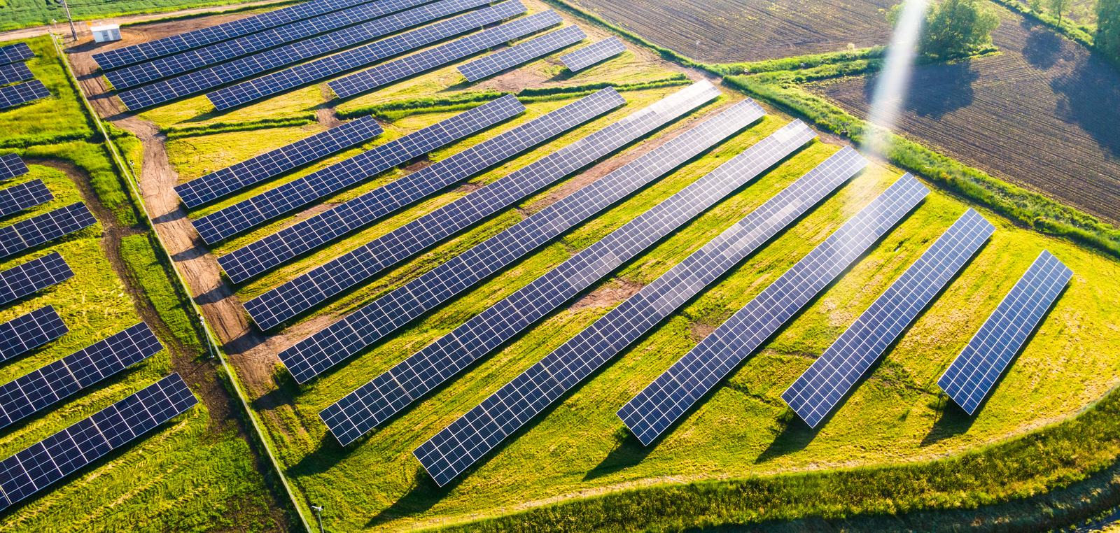 Solar farm among cultivated fields, seen from a drone