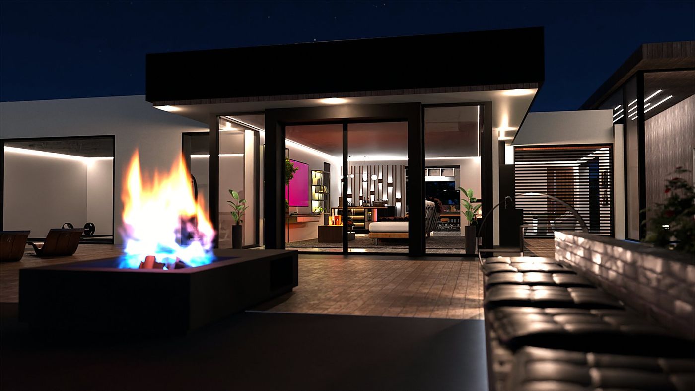 The terrace at night: the fire bowl lit in front of the glazed living room